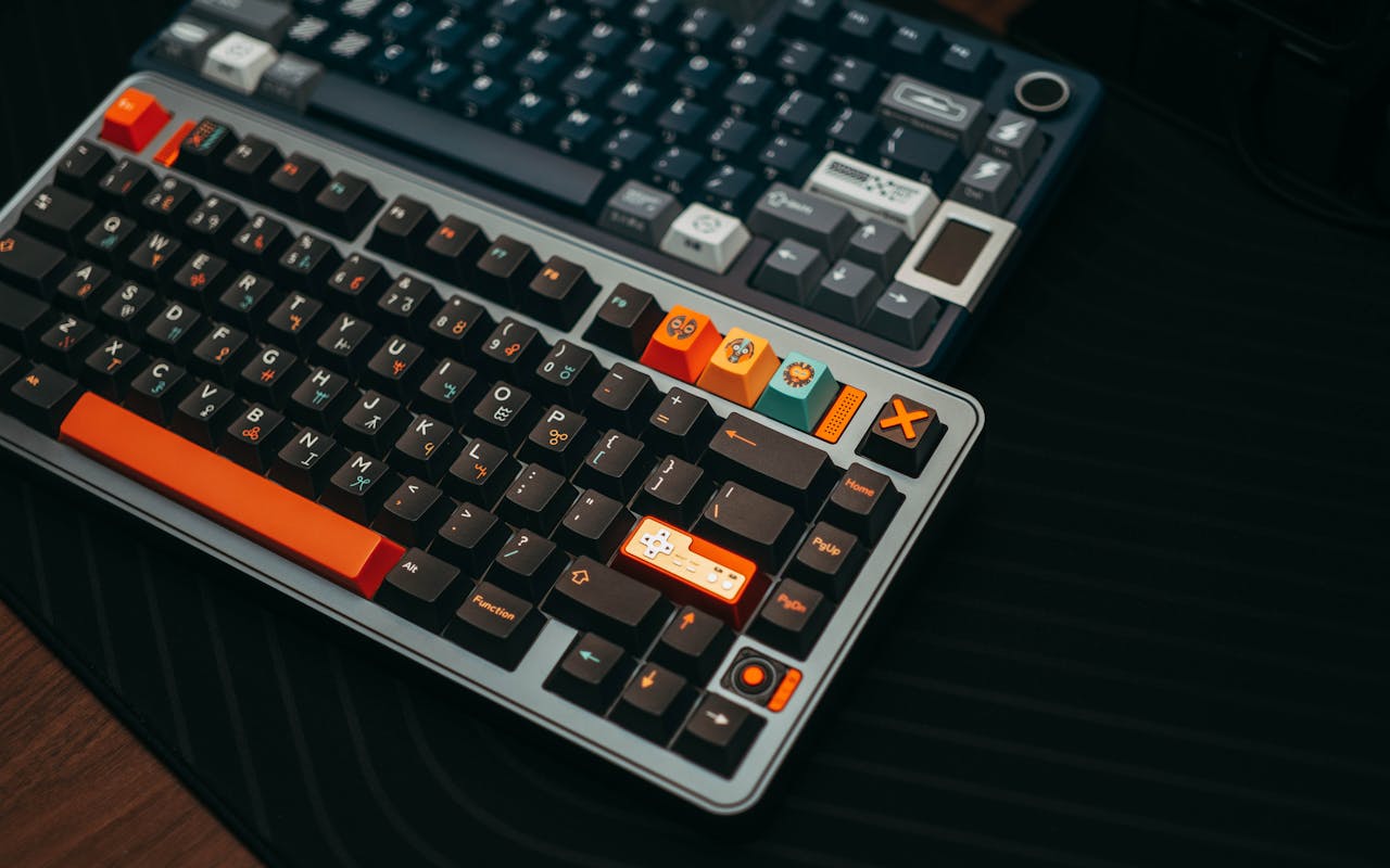Home Close-up of colorful mechanical keyboards on a desk, showcasing unique keycaps and modern design.